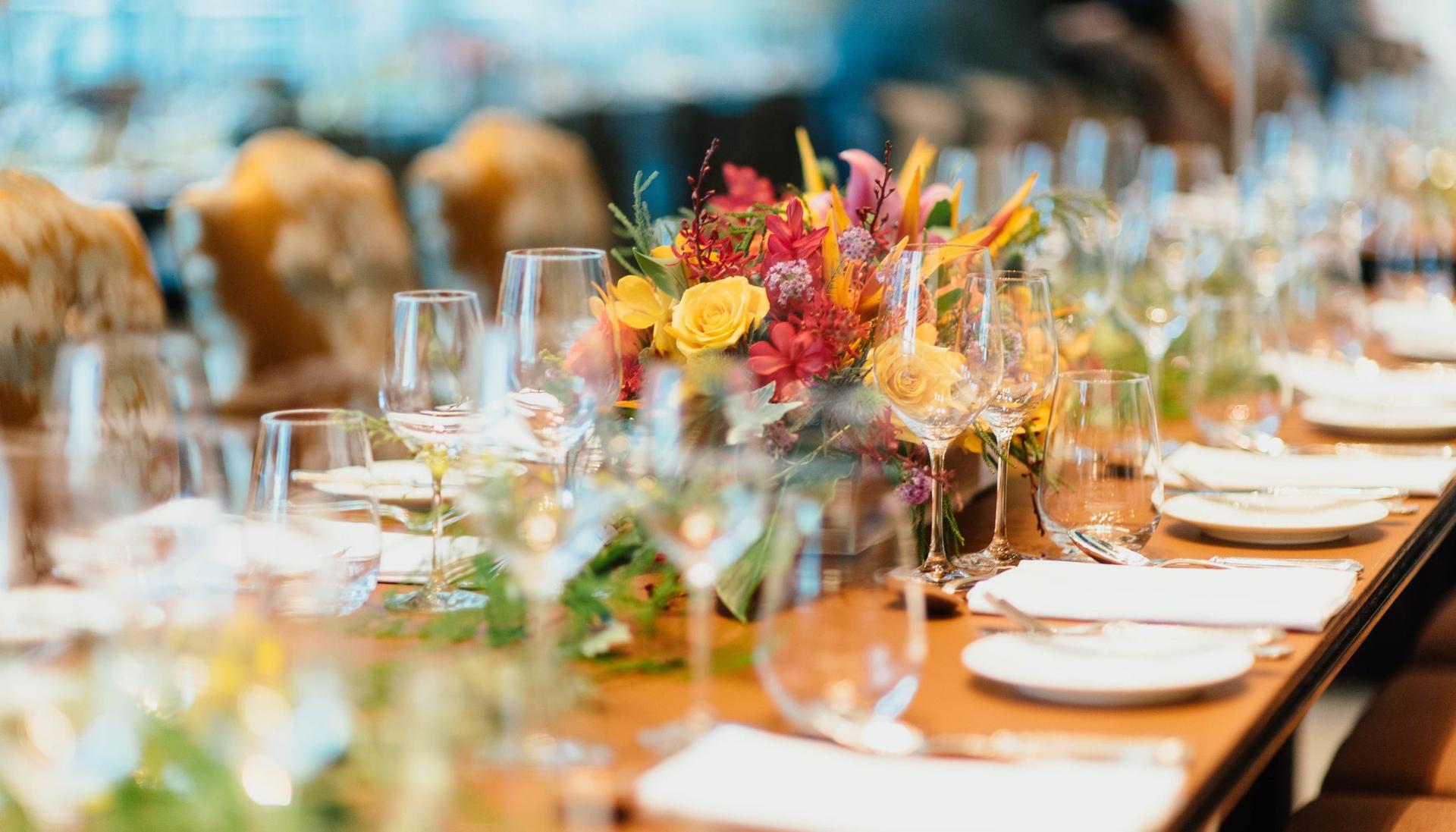 table with flowers and glassware, laid out for an event